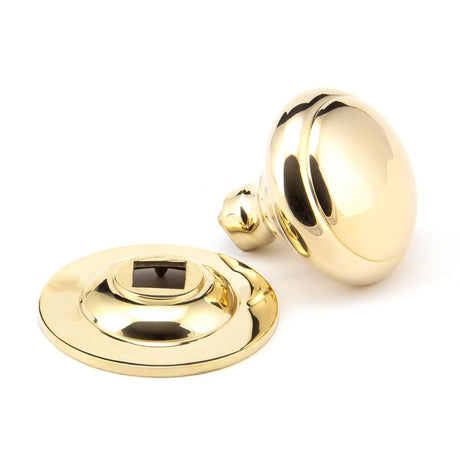 This is an image showing From The Anvil - Polished Brass Round Centre Door Knob available from trade door handles, quick delivery and discounted prices