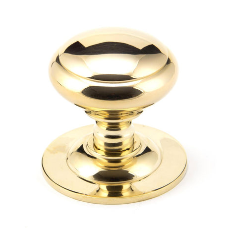This is an image showing From The Anvil - Polished Brass Round Centre Door Knob available from trade door handles, quick delivery and discounted prices
