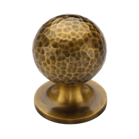 This is an image of a Heritage Brass - Cabinet Knob Ball Hammered Design 32mm Antique Brass finish, ham8321-32-at that is available to order from Trade Door Handles in Kendal.