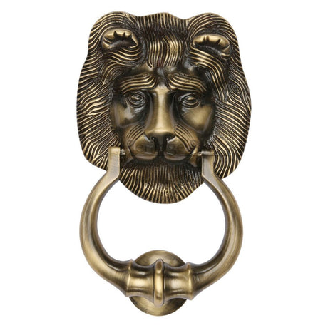 This is an image of a Heritage Brass - Lion Knocker Antique Brass Finish, k1210-at that is available to order from Trade Door Handles in Kendal.