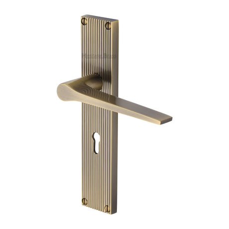 This is an image of a Heritage Brass - Gio Reeded Lever Lock Antique Brass finish, rr4700-at that is available to order from Trade Door Handles in Kendal.