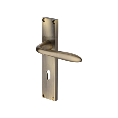 This is an image of a Heritage Brass - Sutton Reeded Lever Lock Antique Brass finish, rr5000-at that is available to order from Trade Door Handles in Kendal.