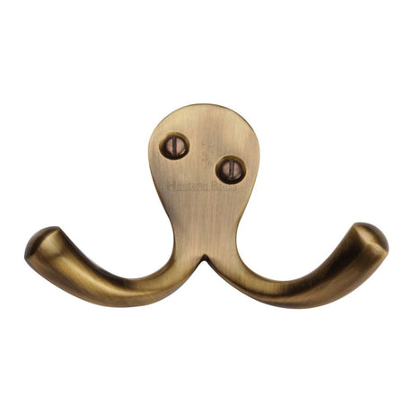 This is an image of a Heritage Brass - Double Coat Hook Antique Brass Finish, v1060-at that is available to order from Trade Door Handles in Kendal.