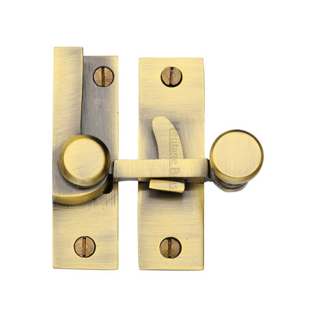 This is an image of a Heritage Brass - Sash Fastener Antique Brass Finish, v1100-at that is available to order from Trade Door Handles in Kendal.