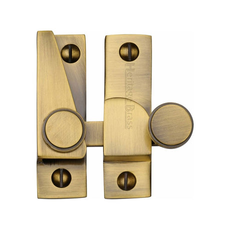 This is an image of a Heritage Brass - Sash Fastener Antique Brass Finish, v1106-at that is available to order from Trade Door Handles in Kendal.