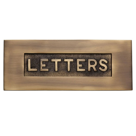 This is an image of a Heritage Brass - Embossed Letterplate 254 x 101mm - Antique Brass Finish, v845-at that is available to order from Trade Door Handles in Kendal.