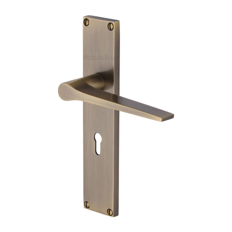 This is an image of a Heritage Brass - Gio Lever Lock Door Handle on 200mm Plate Antique Brass finish, vt8100-at that is available to order from Trade Door Handles in Kendal.