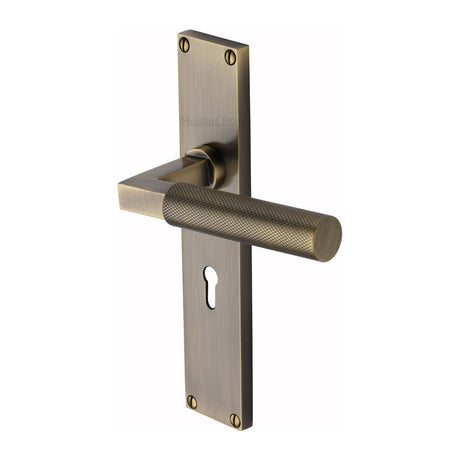This is an image of a Heritage Brass - Bauhaus Knurled Lever Lock Door Handle on 200mm Plate Antique Brass finish, vt9300-at that is available to order from Trade Door Handles in Kendal.