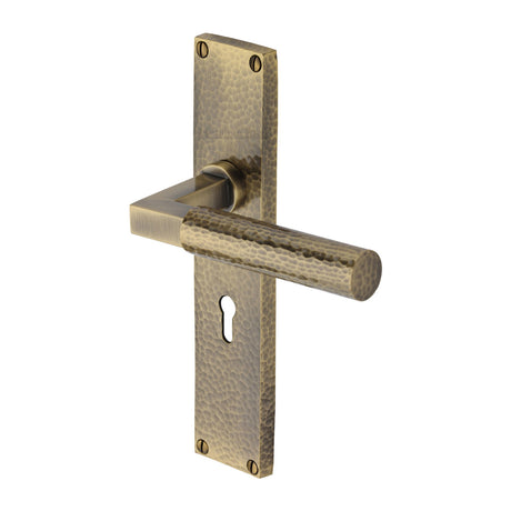 This is an image of a Heritage Brass - Bauhaus Hammered Lever Lock Door Handle on 200mm Plate Antique Brass finish, vth4300-at that is available to order from Trade Door Handles in Kendal.