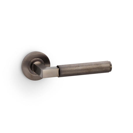 This is an image showing Alexander & Wilks Hurricane Knurled Lever on Round Rose - Dark Bronze PVD aw200dbzpvd available to order from Trade Door Handles in Kendal, quick delivery and discounted prices.