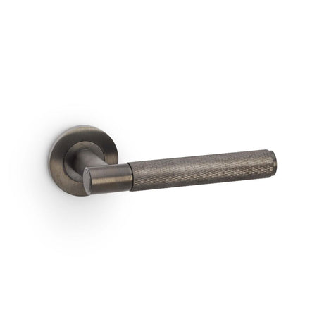 This is an image showing Alexander & Wilks Spitfire Knurled Lever on Round Rose - Dark Bronze PVD aw220dbzpvd available to order from Trade Door Handles in Kendal, quick delivery and discounted prices.