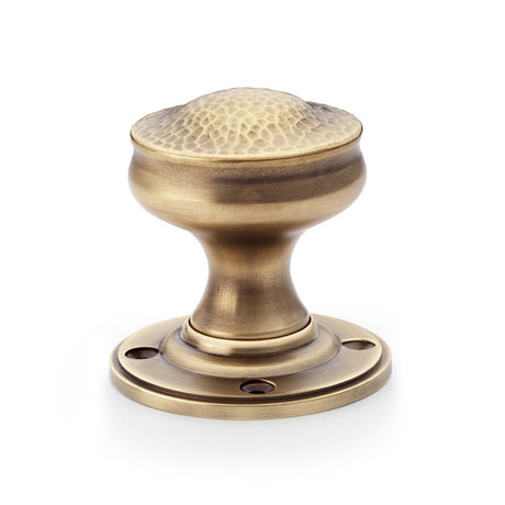 This is an image showing Alexander & Wilks Hammered Mortice Knob - Antique Brass aw302-50-ab available to order from Trade Door Handles in Kendal, quick delivery and discounted prices.