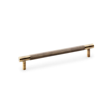 This is an image showing Alexander & Wilks Brunel Knurled T-Bar Cupboard Handle - Antique Brass - Centres 160mm aw810-160-ab available to order from Trade Door Handles in Kendal, quick delivery and discounted prices.