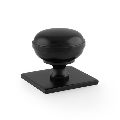 This is an image showing Alexander & Wilks Quantock Cupboard Knob on Square Backplate - Black - 38mm aw826-38-bl available to order from Trade Door Handles in Kendal, quick delivery and discounted prices.