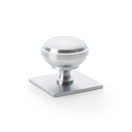 This is an image showing Alexander & Wilks Quantock Cupboard Knob on Square Backplate - Satin Chrome - 38mm aw826-38-sc available to order from Trade Door Handles in Kendal, quick delivery and discounted prices.