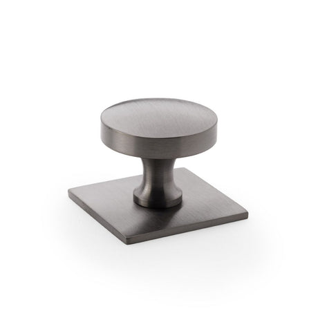 This is an image showing Alexander & Wilks Bullion Cupboard Knob on Square Backplate - Dark Bronze PVD aw835-38-dbzpvd available to order from Trade Door Handles in Kendal, quick delivery and discounted prices.