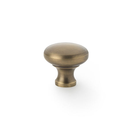 This is an image showing Alexander & Wilks Wade Round Cupboard Knob - Antique Brass - 32mm aw836-32-ab available to order from Trade Door Handles in Kendal, quick delivery and discounted prices.