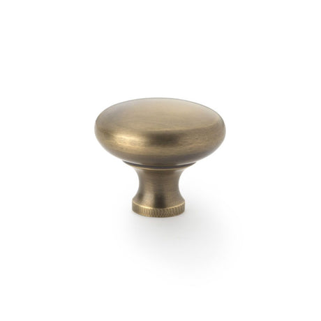 This is an image showing Alexander & Wilks Wade Round Cupboard Knob - Antique Brass - 38mm aw836-38-ab available to order from Trade Door Handles in Kendal, quick delivery and discounted prices.