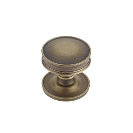 This is an image of a Burlington - Berkeley cupboard knob - Antique Brass  that is availble to order from Trade Door Handles in Kendal.