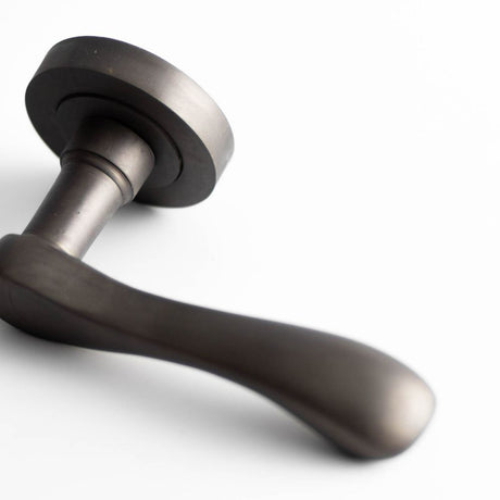 This is an image of a Frelan - Gamma Levers on Round Rose - Dark Bronze  that is availble to order from Trade Door Handles in Kendal.