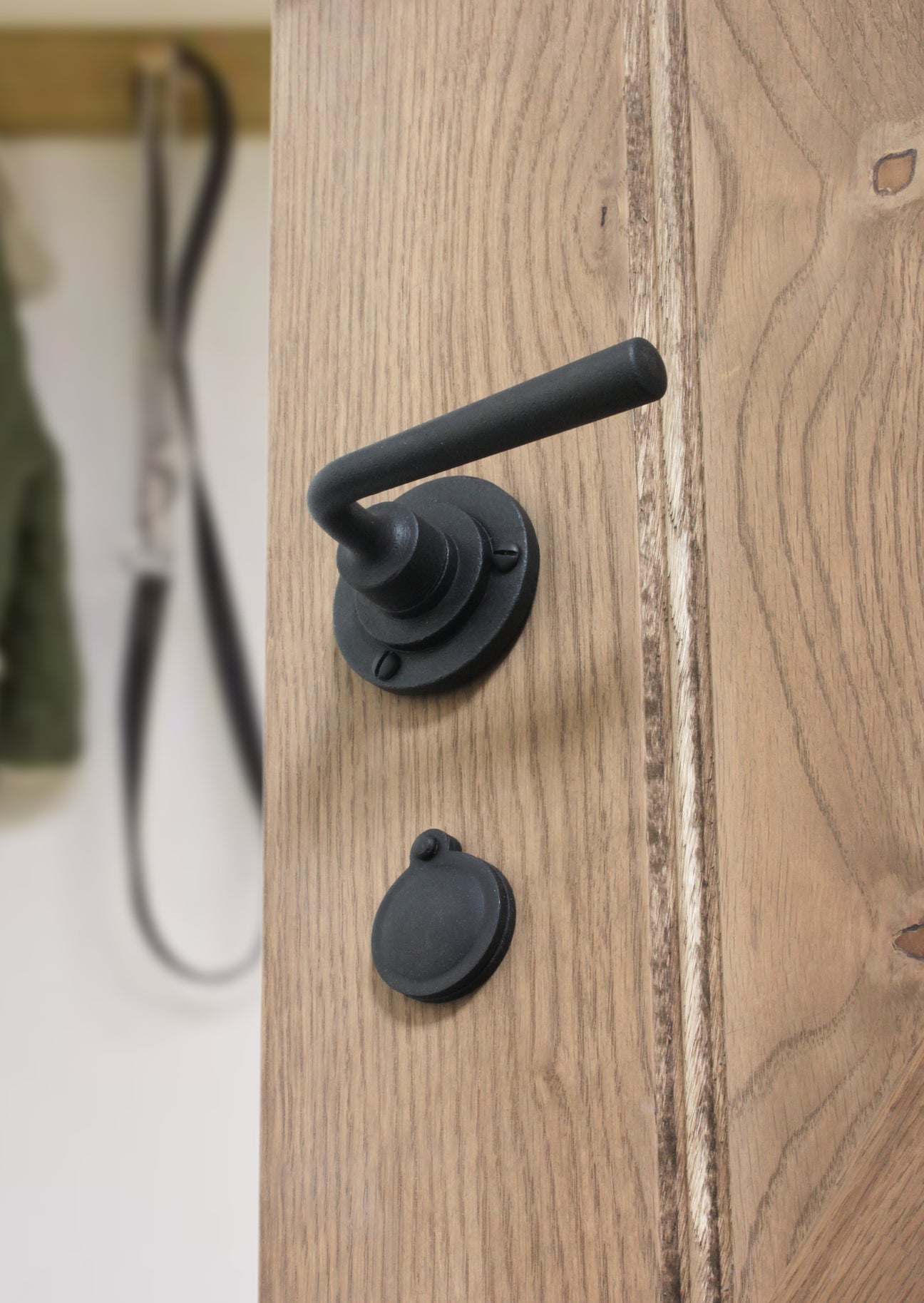 Image showing a door handle on a rose in smooth matt black from Stonebridge.  Available to order from Trade Door Handles in Kendal