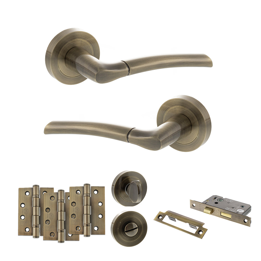 Quality image of STATUS Indiana Door Handle Pack (Bathroom Set - 2.5" CE Bathroom Lock, 4" Fire Rated Hinges x3) - Antique Brass | Sku. adps33rab10 | available from Trade Door Handles.