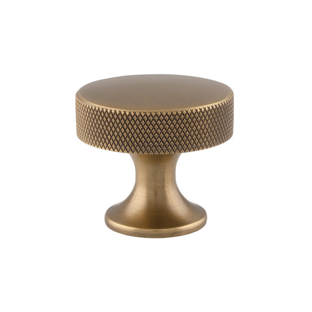 This is an image showing Alexander & Wilks Berlin Cupboard Knob - Antique Brass - 38mm available to order from Trade Door Handles in Kendal, quick delivery and discounted prices