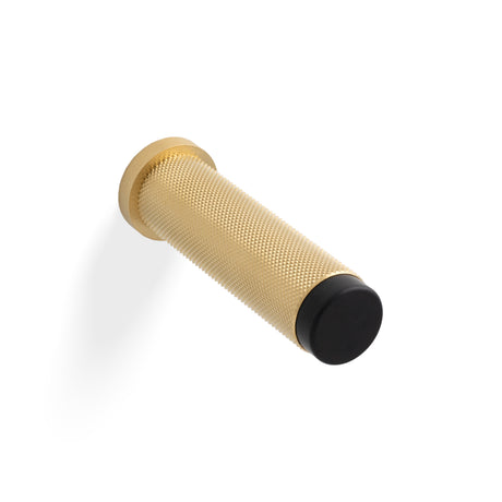 High quality image of Valli 76 x 20mm - Wall Mounted Knurled Doorstop on Rose - Concealed Fix - Satin Brass PVD| Sku. K1401SBPVD |Trade Door Handles.