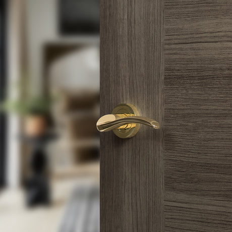 Quality image of Mediterranean Valencia Lever Door Handle on Round Rose - Polished Brass | Sku. m85bp | available from Trade Door Handles.