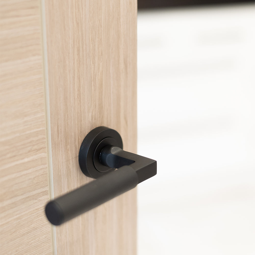 Quality image of Millhouse Brass Cartwright Knurled Lever Door Handle on Round Rose - Matt Black | Sku. mhr200mb | available from Trade Door Handles.