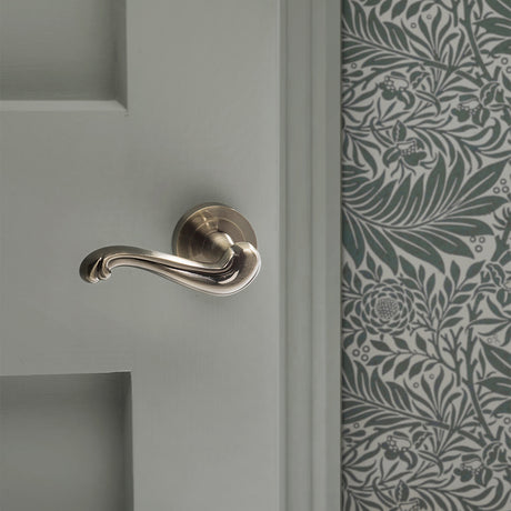 Quality image of Old English Colchester Lever Door Handle on Round Rose - Antique Brass | Sku. oe177ab | available from Trade Door Handles.