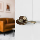 Quality image of Old English Warwick Lever Door Handle on Round Rose - Antique Brass | Sku. oe178ab | available from Trade Door Handles.