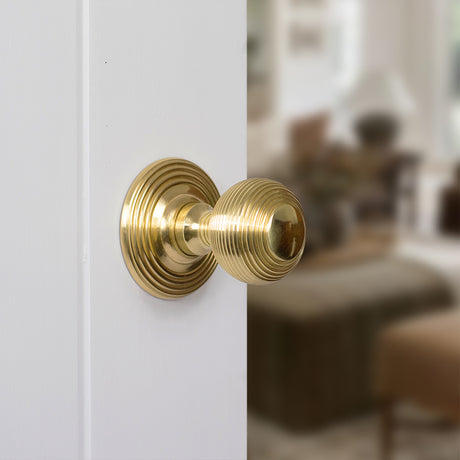 Quality image of Old English Ripon Solid Brass Reeded Mortice Knob on Concealed Fix Rose - Polished Brass | Sku. oe50rmkpb | available from Trade Door Handles.