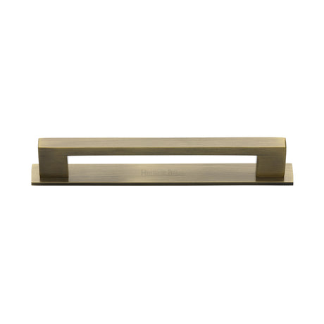 High quality image of the Heritage Brass Cabinet Pull Metro Design with Plate 128mm CTC Antique Brass Finish | Sku. pl0337-128-at | Discounted prices available from Trade Door Handles