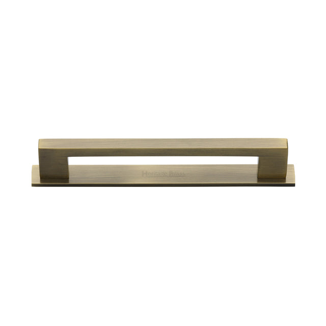High quality image of the Heritage Brass Cabinet Pull Metro Design with Plate 128mm CTC Antique Brass Finish | Sku. pl0337-128-at | Discounted prices available from Trade Door Handles