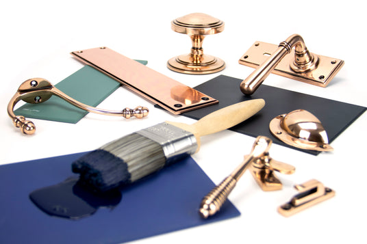 This image shows a collection of ironmongery by From The Anvil in a polished bronze finish.  Available to order from Trade Door Handles in Kendal