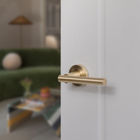 Quality image of STATUS Nebraska Lever Door Handle on Round Rose - Satin Brass | Sku. s28rsb | available from Trade Door Handles.