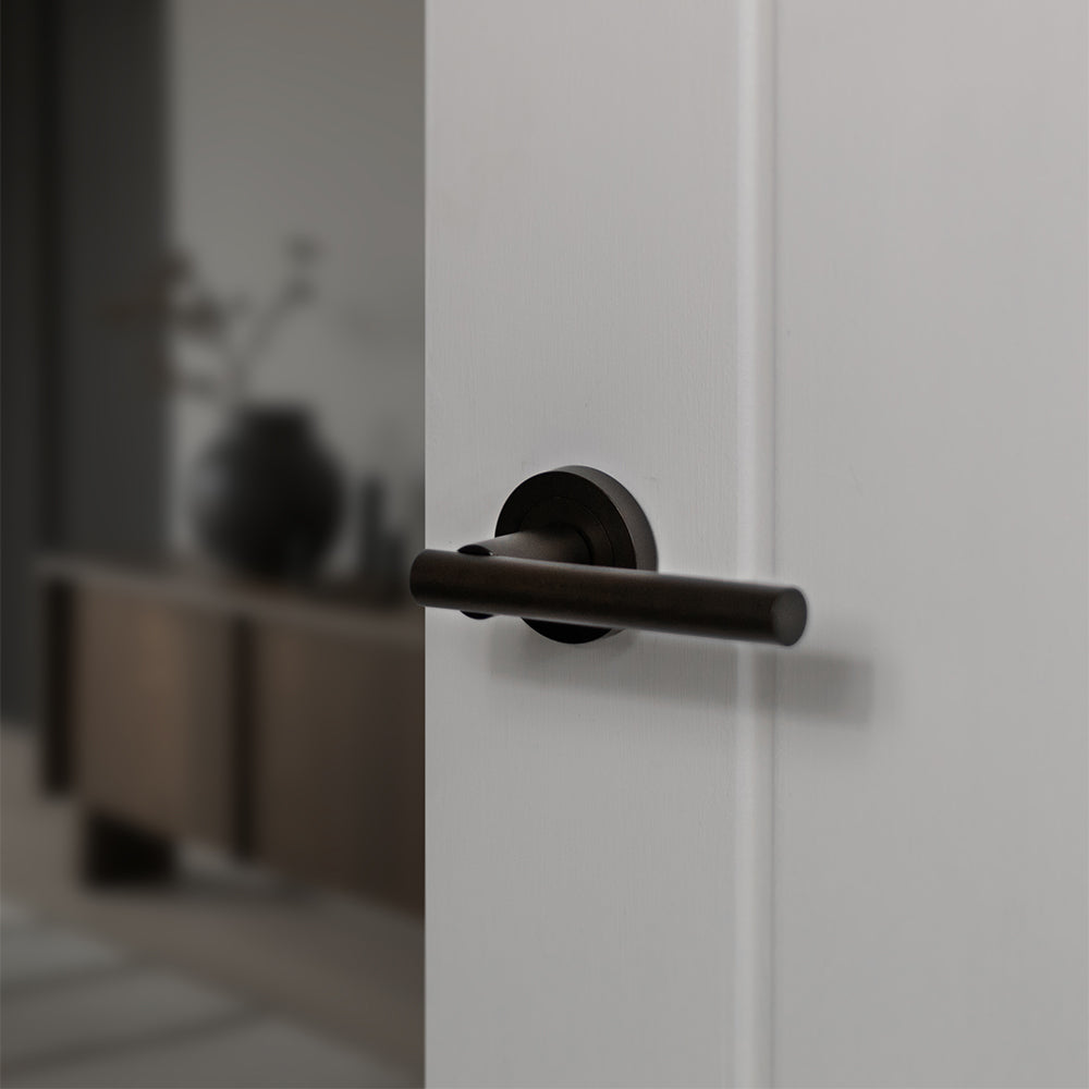 Quality image of STATUS Nebraska Lever Door Handle on Round Rose - Urban Dark Bronze | Sku. s28rudb | available from Trade Door Handles.