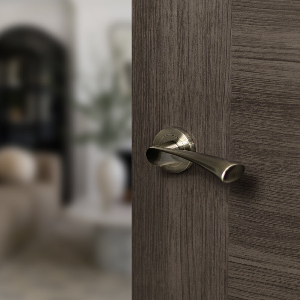 Quality image of STATUS Colorado Lever Door Handle on Round Rose - Antique Brass | Sku. s34rab | available from Trade Door Handles.