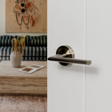 Quality image of STATUS Alabama Lever Door Handle on Round Rose - Antique Brass | Sku. s43rab | available from Trade Door Handles.