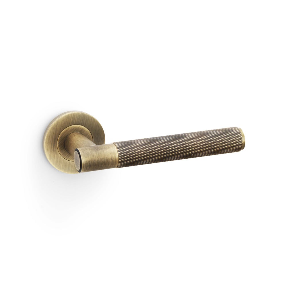 High quality image of Alexander & Wilks - Spitfire Knurled Lever on Round Rose - Antique Brass | Sku. aw220ab | Trade Door Handles.