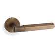 This is an image showing Alexander & Wilks - Spitfire Hex Lever on Round Rose - Italian Brass aw224ib available to order from Trade Door Handles in Kendal, quick delivery and discounted prices.