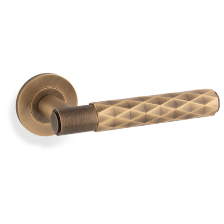 This is an image of Alexander & Wilks - SPITFIRE LEVER DIAMOND CUT ON 50X6MM ROSE - Antique Brass available to order from Trade Door Handles in Kendal, quick delivery and discounted prices.