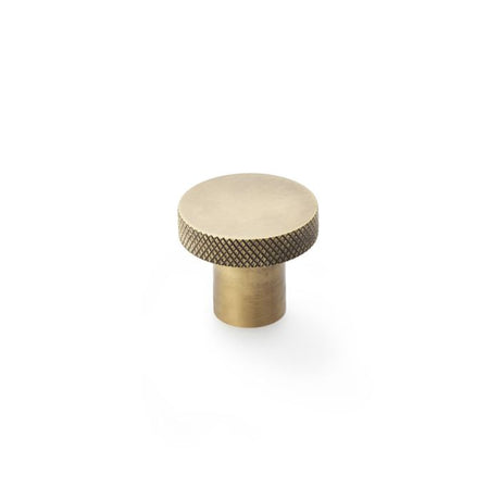 This is an image showing Alexander & Wilks Hanover Knurled Circular Cupboard Knob - Antique Brass - 30mm available to order from Trade Door Handles in Kendal, quick delivery and discounted prices