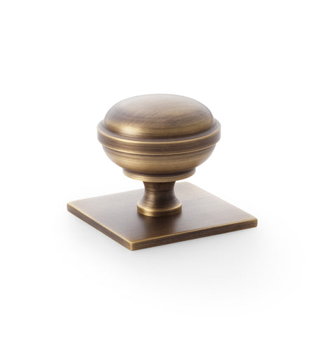 High quality image of Alexander & Wilks Quantock Cupboard Knob on Square Backplate - Antique Brass - 38mm | Sku. aw826-38-ab | Trade Door Handles.