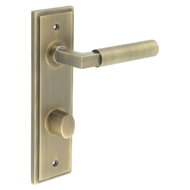 This is an image showing the Frelan - Westminster Door Handle Din Bathroom Backplate Antique Brass & Turn & Release available to order from Trade Door Handles in Kendal