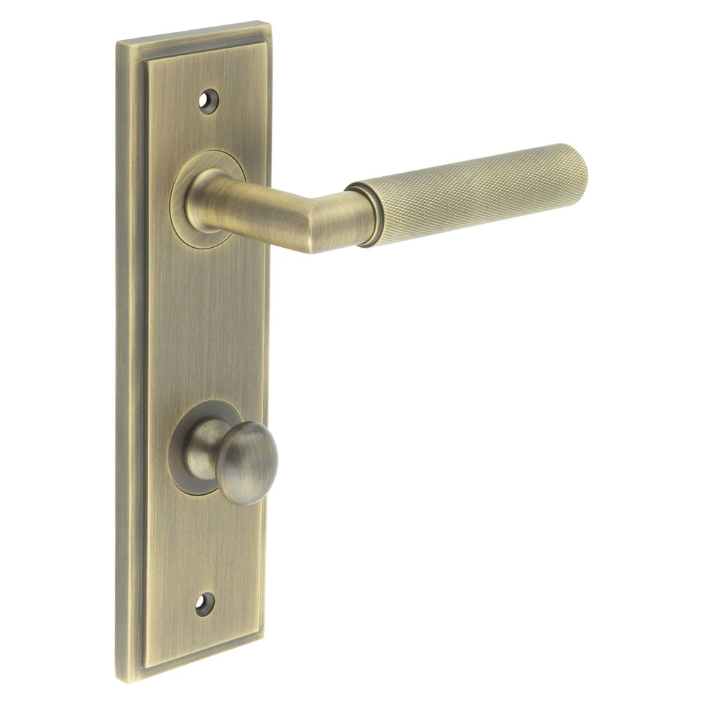 This is an image showing the Frelan - Piccadilly Door Handle Din Bathroom Backplate Antique Brass & Turn & Release available to order from Trade Door Handles in Kendal