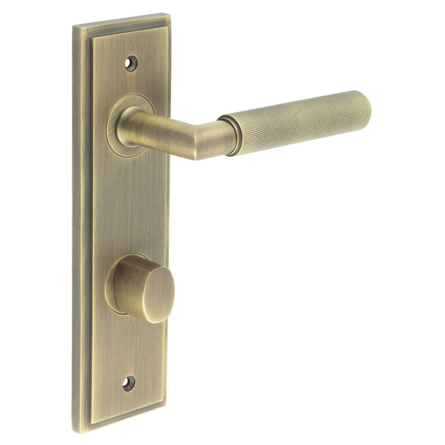 This is an image showing the Frelan - Piccadilly Door Handle Din Bathroom Backplate Antique Brass & Turn & Release available to order from Trade Door Handles in Kendal