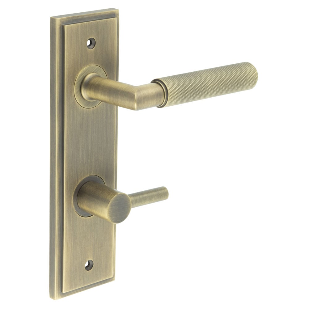 This is an image showing the Frelan - Piccadilly Door Handle Din Bathroom Backplate Antique Brass & Turn & Release available to order from Trade Door Handles in Kendal