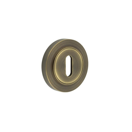 This is an image showing the Frelan - Burlington Standard Keyway Escutcheons Plain Rose Antique Brass available to order from Trade Door Handles in Kendal